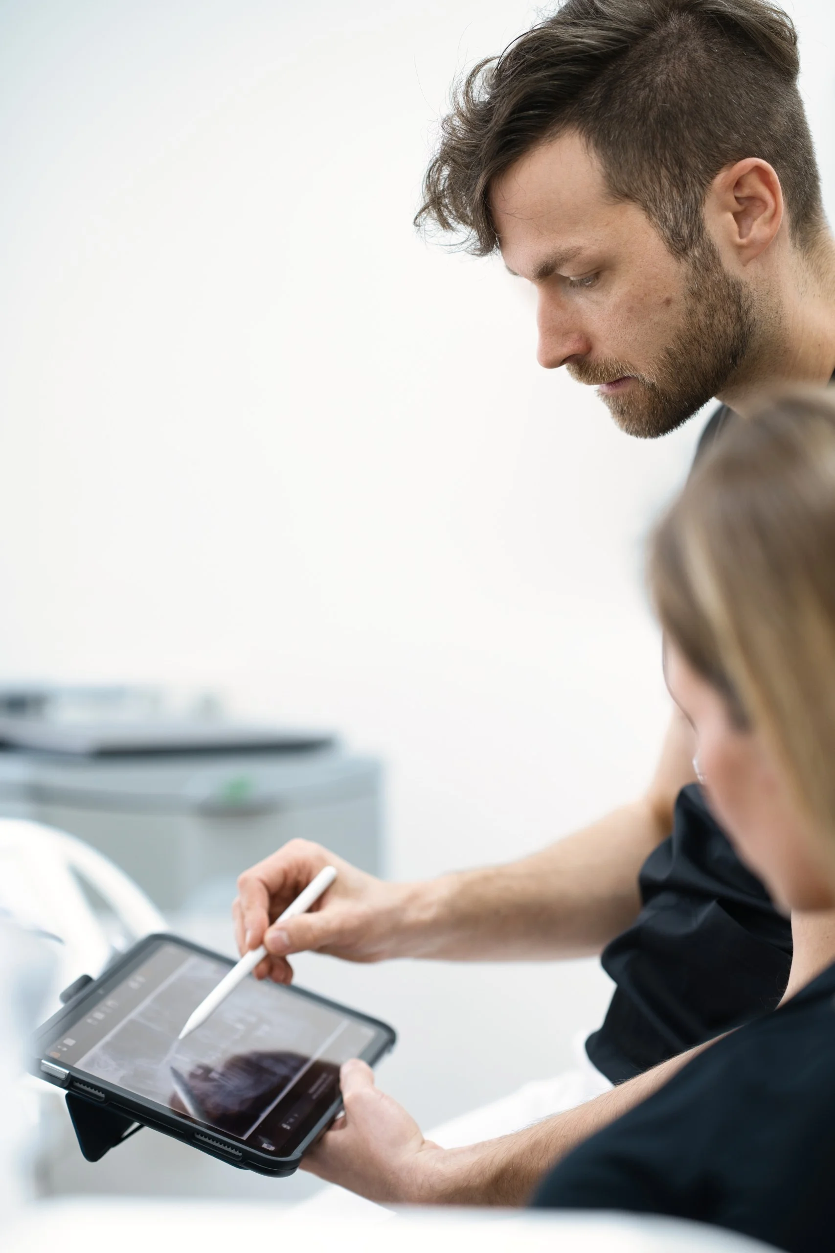 Dr. Felix Löffler erläutert die digitale Planung einer komplexen Zahnbehandlung auf einem Tablet.