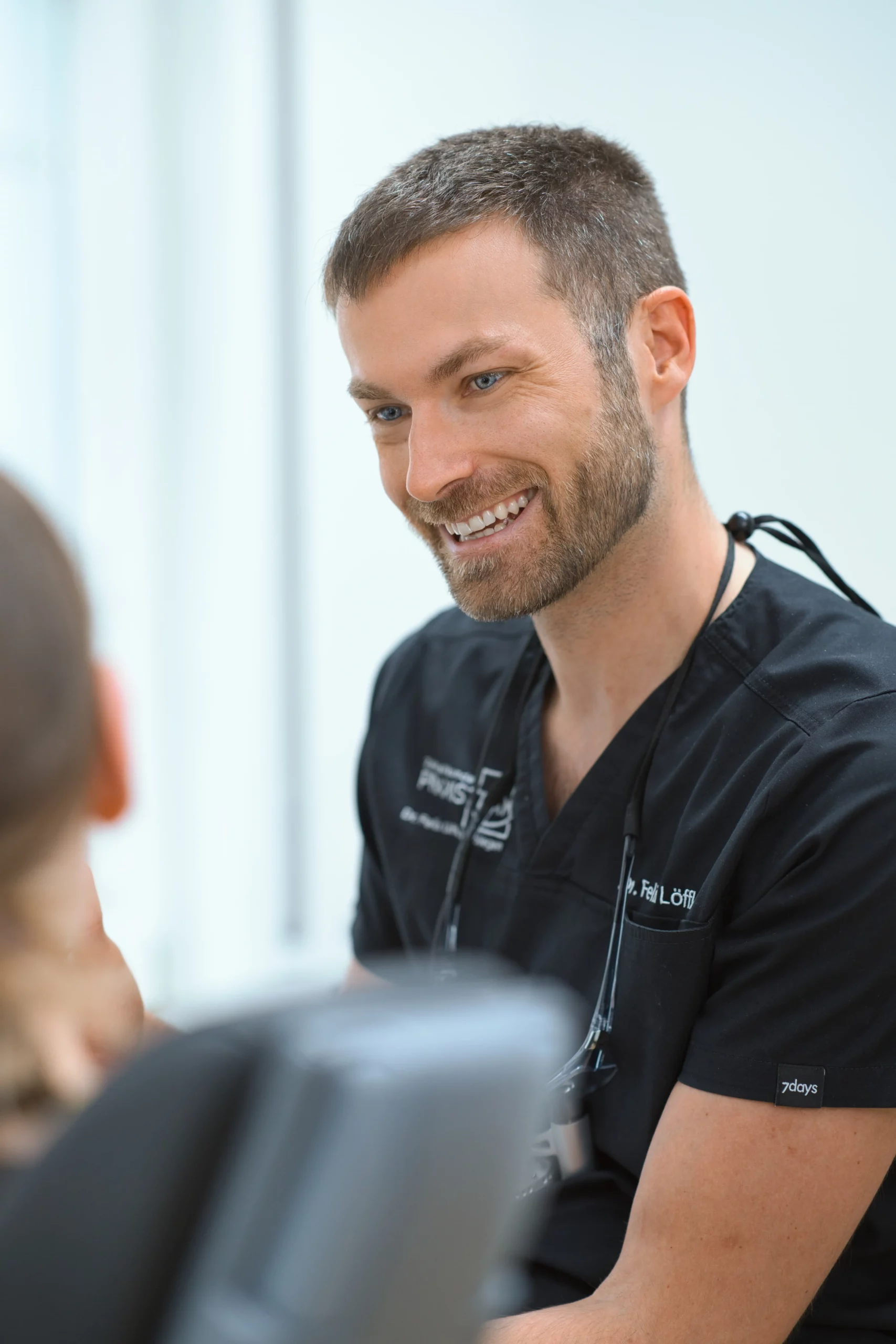 Zahnarzt im persönlichen Beratungsgespräch mit einer Patientin